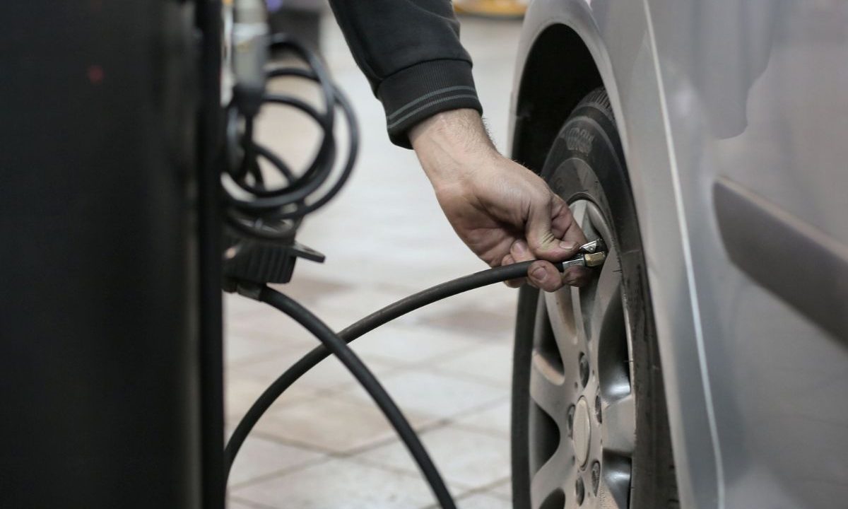 Inflating a car tire with a compact air compressor hose