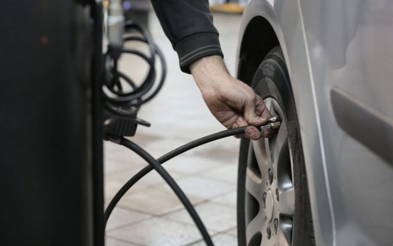 Inflating a car tire with a compact air compressor hose